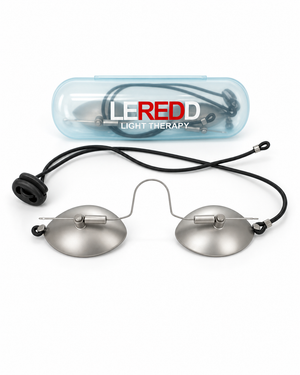 A pair of LEREDD Light Therapy IPL Steel goggles with oval silver metal lenses, a black adjustable elastic round strap, and a clear plastic carrying case with the LEREDD brand logo, shown on a white background.